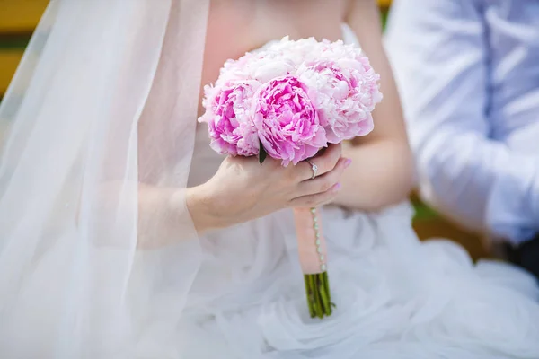 柔和的粉色牡丹花束坐在新娘的手里 — 图库照片
