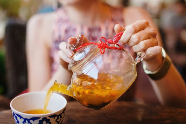 Жіночий Hnds розливу в скляні чайник море обліпихи чай — стокове фото