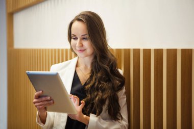Şık kadın kullanımı modern teknolojiler. Genç kız tablet ile standları