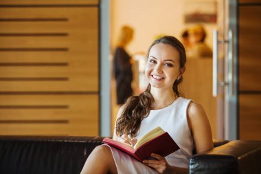 Kadın kanepede oturan ve kalem ve günlük tutma