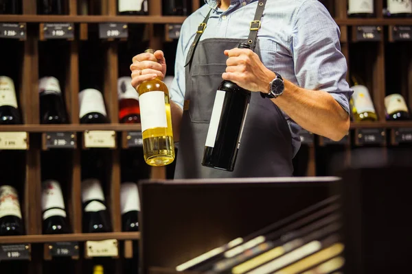 Genç sommelier şişe kırmızı şarap mahzeninde tutuyor — Stok fotoğraf