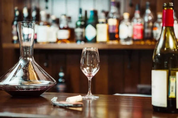 Декантер з вином і келихом на барній стійці — стокове фото
