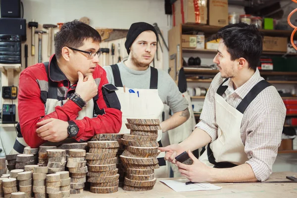 Drie werknemers bepaald werkproces op hout behandelingen — Stockfoto