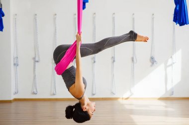 Kız pembe ipek hamak üzerinde inversiyon poz içinde ters