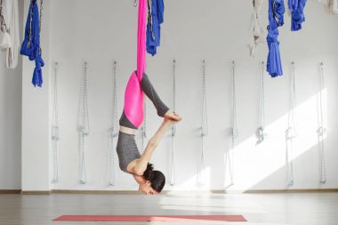 Kız pembe ipek hamak üzerinde inversiyon poz içinde ters