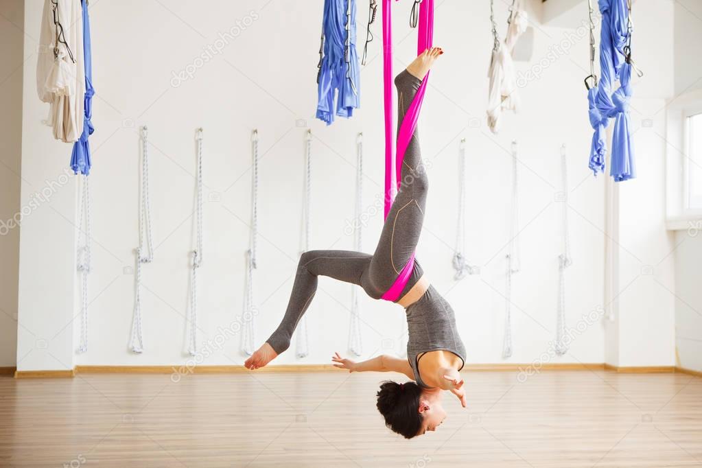 Star Inversion aerial antigravity yoga pose, woman exerciseses with hammock
