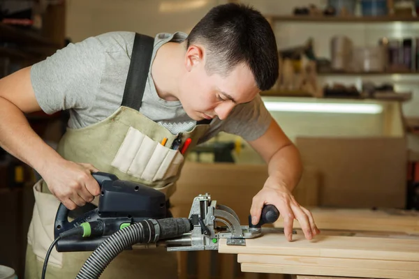 Man aan het werk met snijwerk apparatuur op workshop. Chinseling groef — Stockfoto