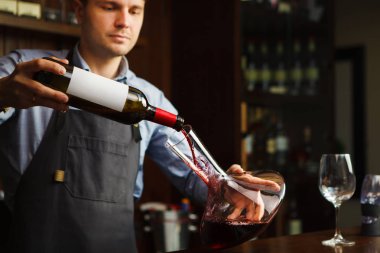 Sommelier şarap cam sürahi içine dökme. Erkek garson