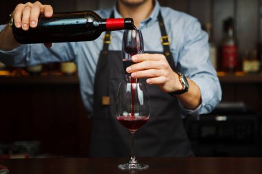 Erkek sommelier aerator aracılığıyla kırmızı şarap cam içine dökme.