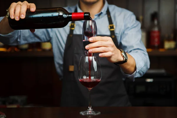 Чоловік сомельє вливає червоне вино через аератор у склянку . — стокове фото