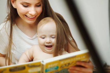 Peri masalları ile küçük bebek renkli kitap okuma anne.