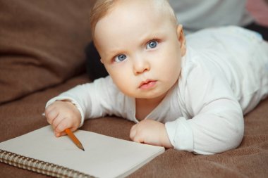 Genç bebek beraberlik öğrenme konsantre. Elinde kalem bebeğim