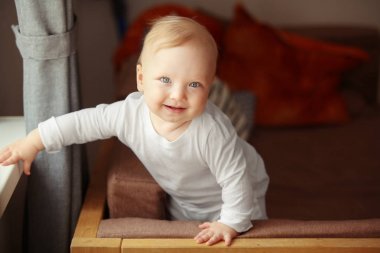 Mutlu bebek ışık gözleri ile kanepede standları