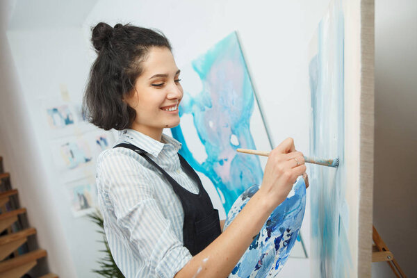 Концентрированная девушка сосредоточена на творческом процессе в арт-терапии
