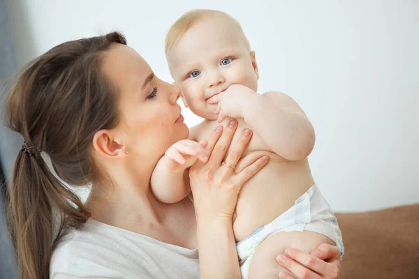 Mother hugs baby toddler smelling his tasty body, happy moments Royalty Free Stock Images