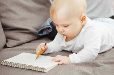 Genç bebek beraberlik öğrenme konsantre. Elinde kalem bebeğim