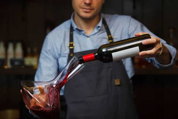 Сомельє наливає вино в склянку з декантера. Чоловічий офіціант — стокове фото