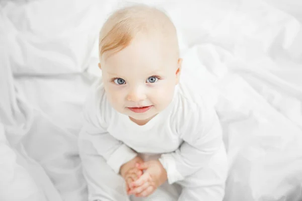 Charming baby with big kind eyes portrait from above