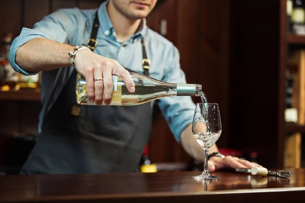 Erkek sommelier beyaz şarap uzun saplı kadehlerin dökme. — Stok fotoğraf