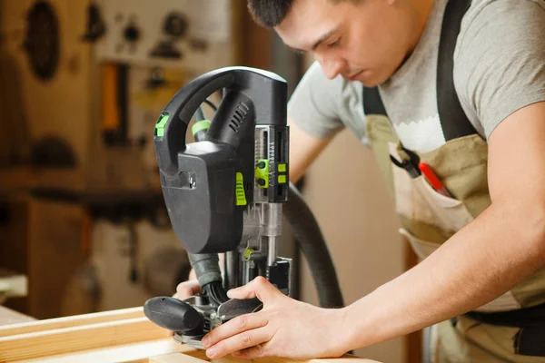 Man aan het werk met snijwerk apparatuur op workshop. Chinseling groef — Stockfoto