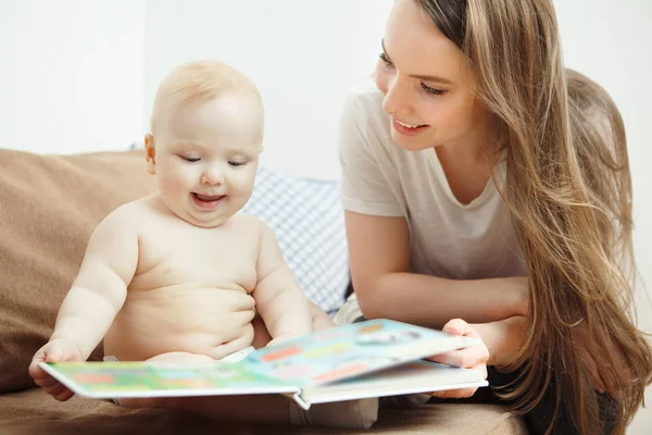 Мать читает маленькому младенцу красочную книгу со сказками . — стоковое фото
