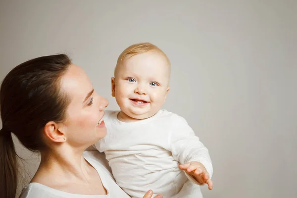 Mujer sosteniendo en brazos a su adorable bebé niño, niño sonriente — Foto de Stock