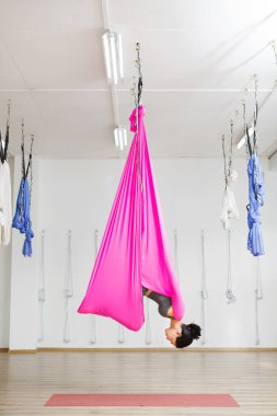 Hamakta baş aşağı asılı kız inversiyon poz.