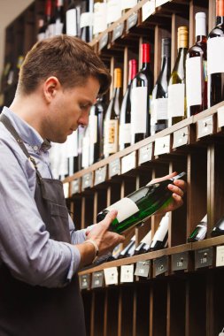 Düşünceli uzman şarap raflara arka plan üzerinde şarap yapımı.