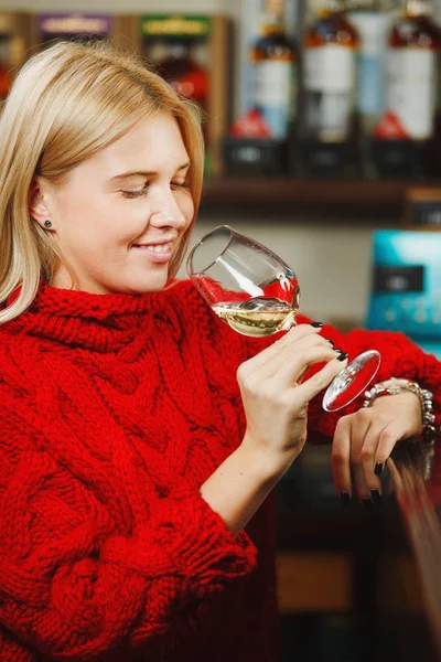 Menina com copo de vinho branco senta-se no balcão de bar — Fotografia de Stock