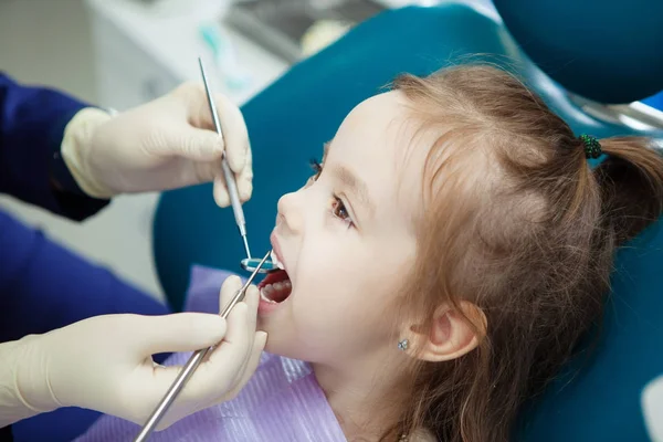 Criança mente em cadeira de dentista e médico faz check-up — Fotografia de Stock