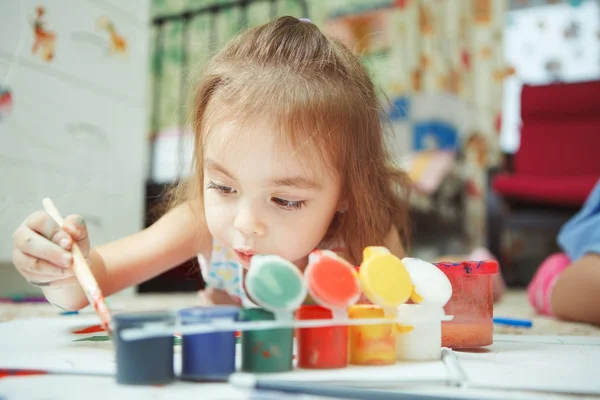 Niña se encuentra en el suelo del dormitorio y pintura cuadro — Foto de Stock