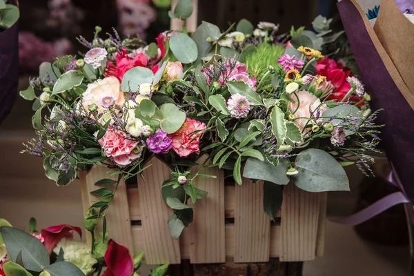 flowers in wooden box with cloves, alstromeria, and greens