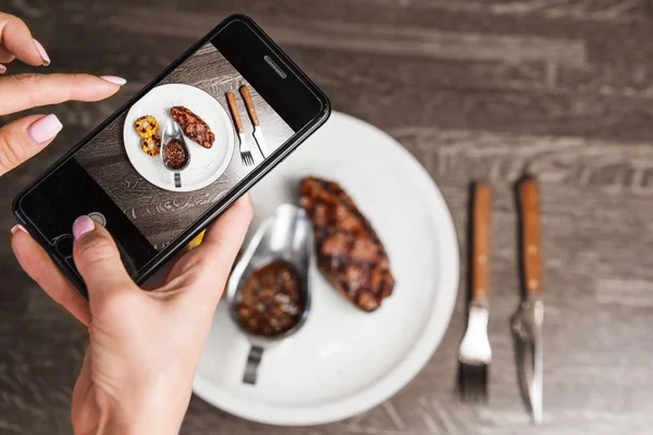 Foto no smartphone de bife com milho grelhado e molho — Fotografia de Stock