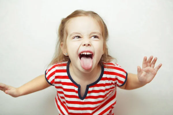 Злий маленька дівчинка показує язик у смішному похмурому — стокове фото
