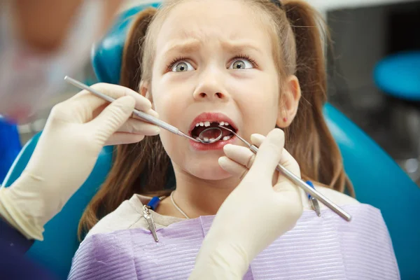 Criança assustada senta-se na cadeira do dentista com a boca aberta — Fotografia de Stock
