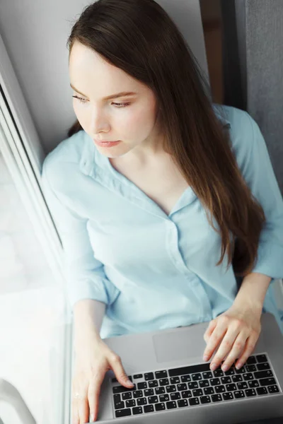 Fiatal nő ül laptop és átgondolt levegő ölében — Stock Fotó