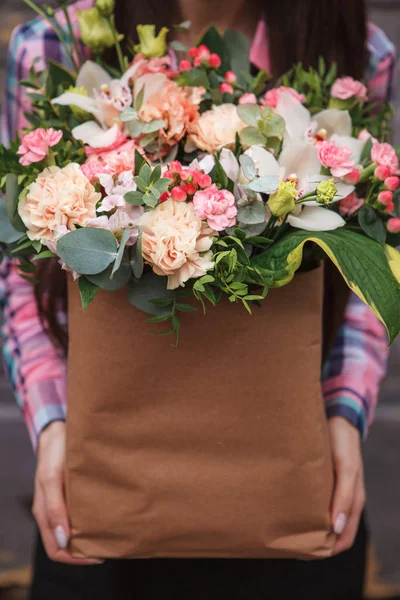 Mains féminines tenant une boîte en papier avec des fleurs — Photo