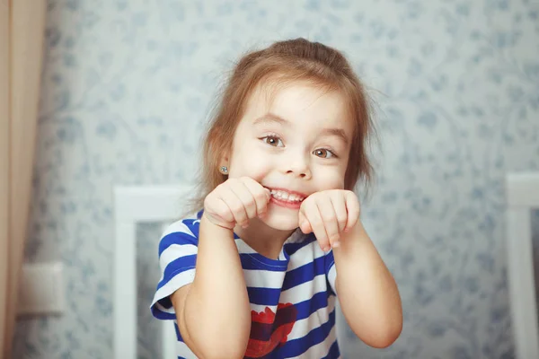 Söt liten flicka i randig T-shirt gör grimas — Stockfoto