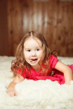 Pembeli kız yatakta yatıyordu elbise ve dil gösterir.