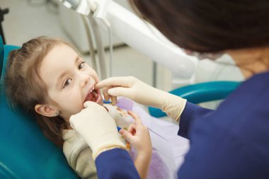 Çocuk ağız diş hekimi lastik eldiven denetler