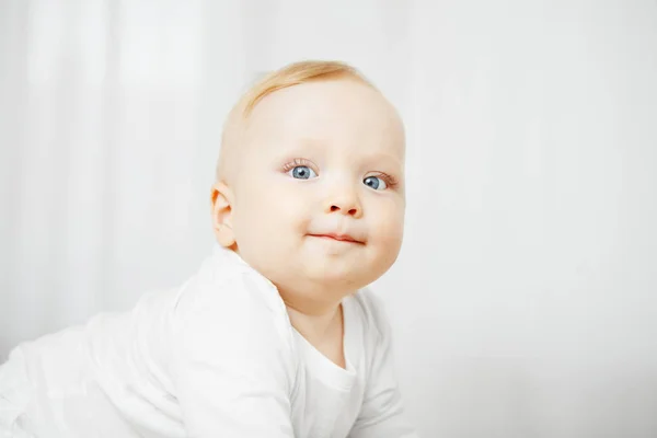 Bebê loiro sorridente com pele perfeita e olhos azuis — Fotografia de Stock