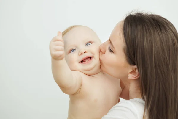 Madre besa a su adorable niño en la mejilla, enfant posando — Foto de Stock