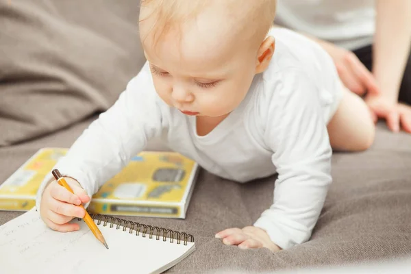 Skoncentrowany maluch nauka rysowania. Dziecko trzymać ołówek w ręku — Zdjęcie stockowe