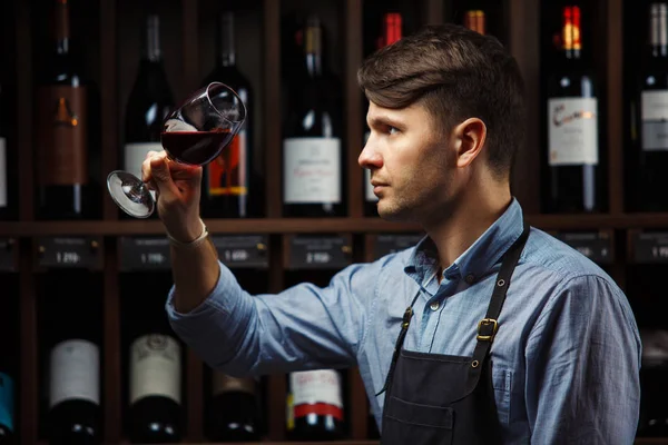 背景为红葡萄酒瓶，男性肉身鉴赏饮料 — 图库照片