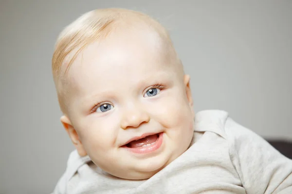Baby met interesse look en brede glimlach — Stockfoto