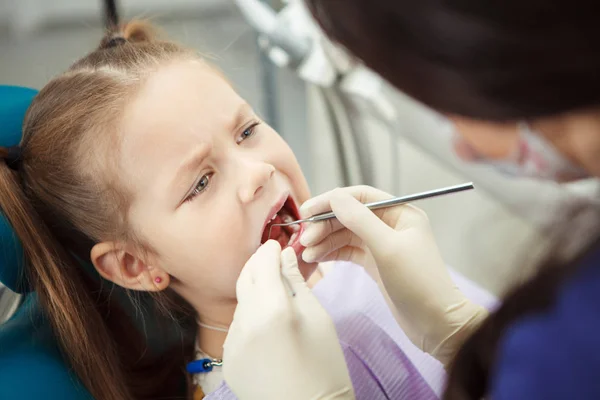 Criança está em cadeira de dentista e passa por procedimento — Fotografia de Stock