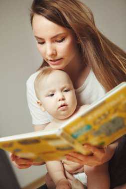Peri masalları ile küçük bebek renkli kitap okuma anne.