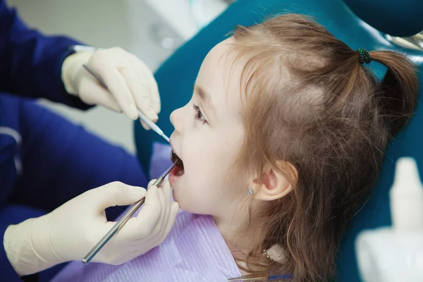 Criança mente em cadeira de dentista e médico faz check-up — Fotografia de Stock