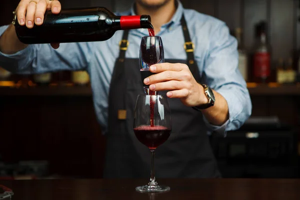 Чоловік сомельє вливає червоне вино через аератор у склянку . — стокове фото