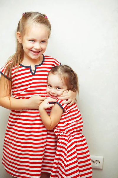 Soeurs avec des coiffures et des robes mêmes s'amuser — Photo